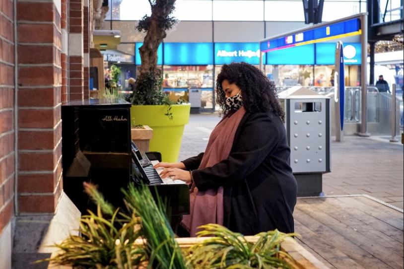 Vrouw speelt piano op station 