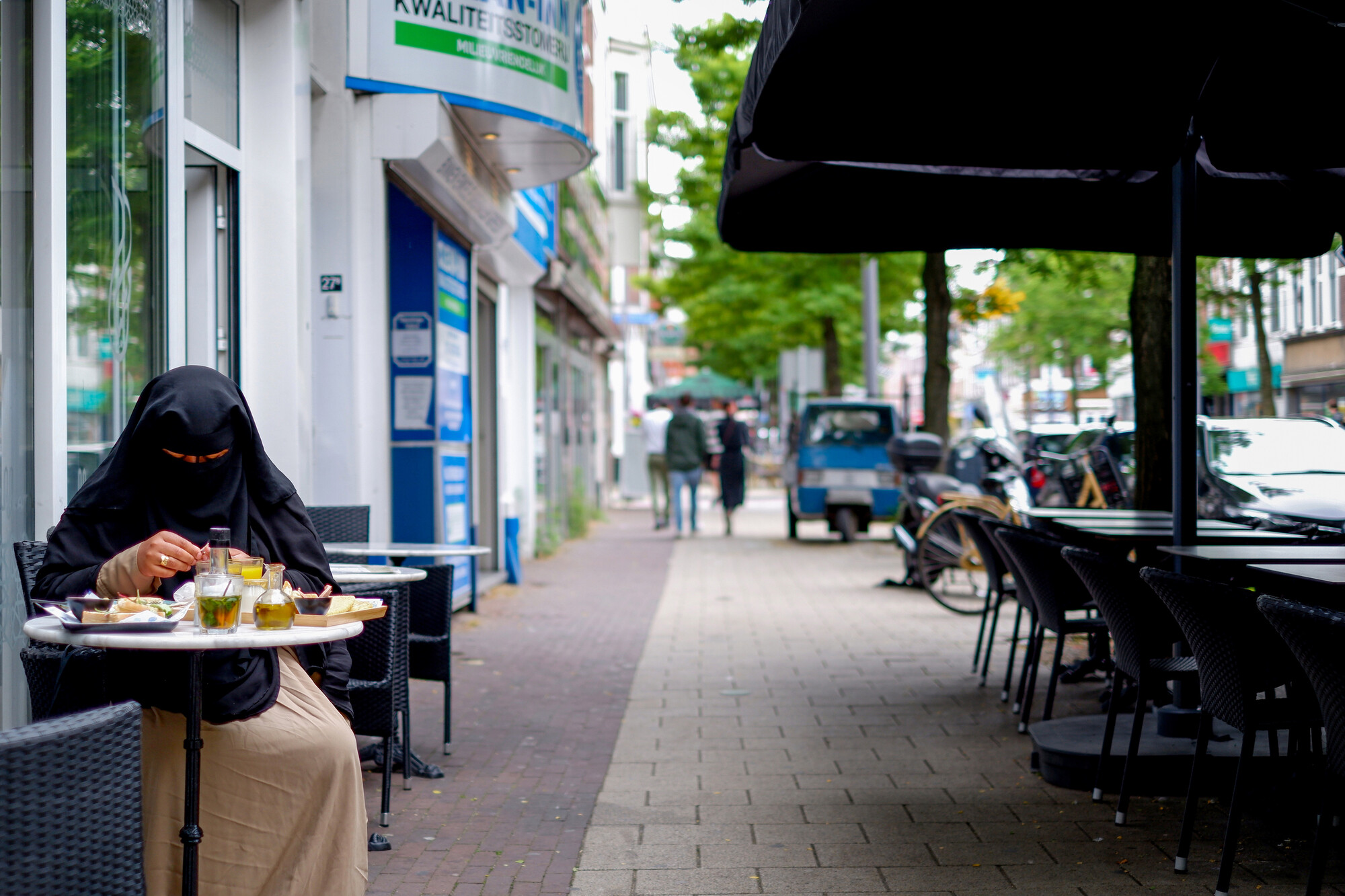 Vrouw eet lunch bij café in Rotterdam