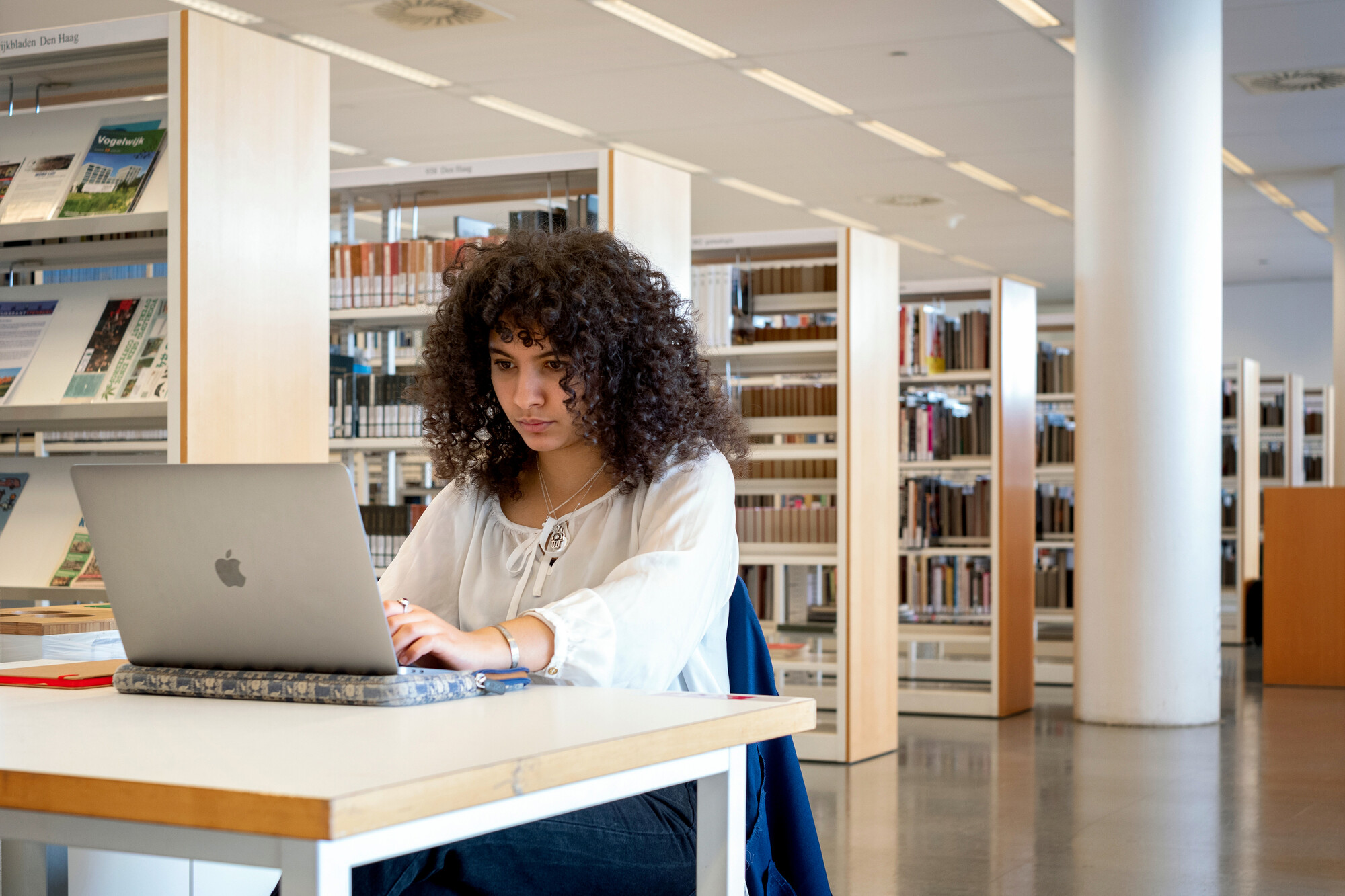 Zijkant van studerende vrouw in bibliotheek 