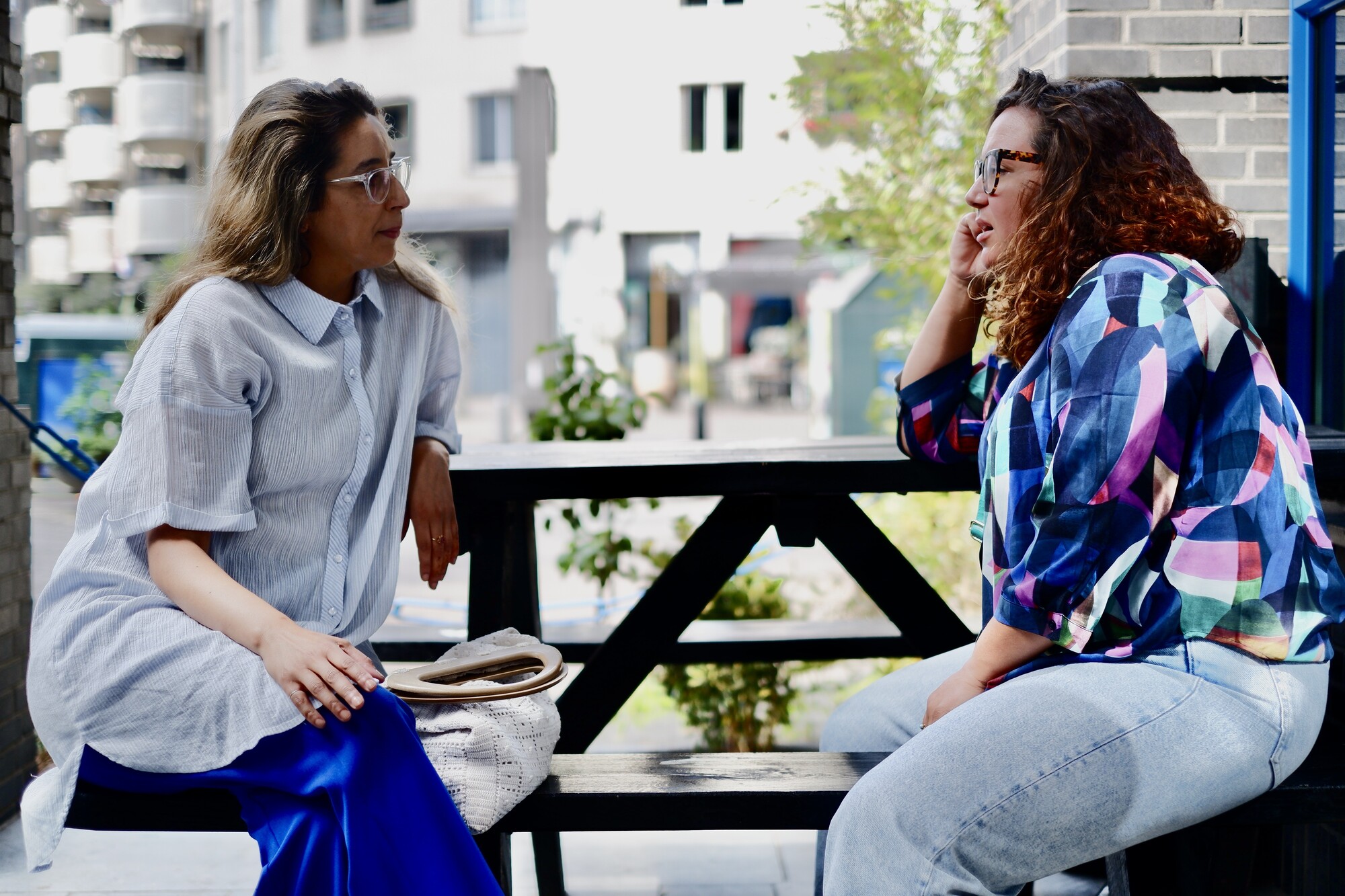Twee vrouwen in gesprek op een picknickbankje