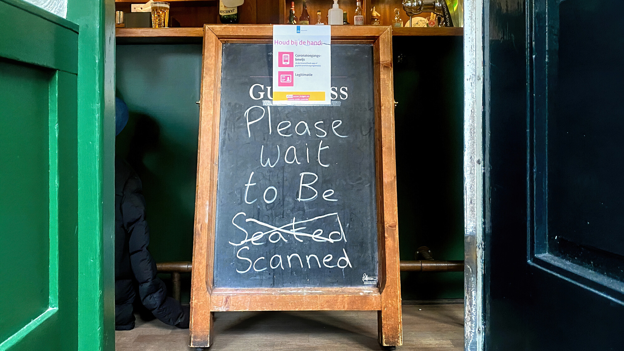 Een restaurant met een bord: wait to be scanned in plaats van wait to be seated
