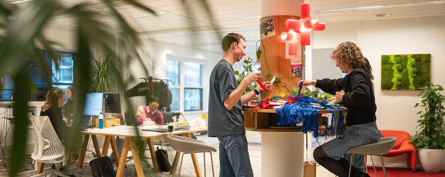 Twee junioren zijn op het EMMA kantoor en sorteren keycords voor een burgerberaad