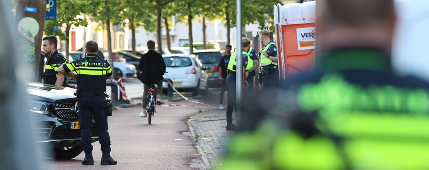 een groep agenten op straat. Op de achtergrond fietst een man