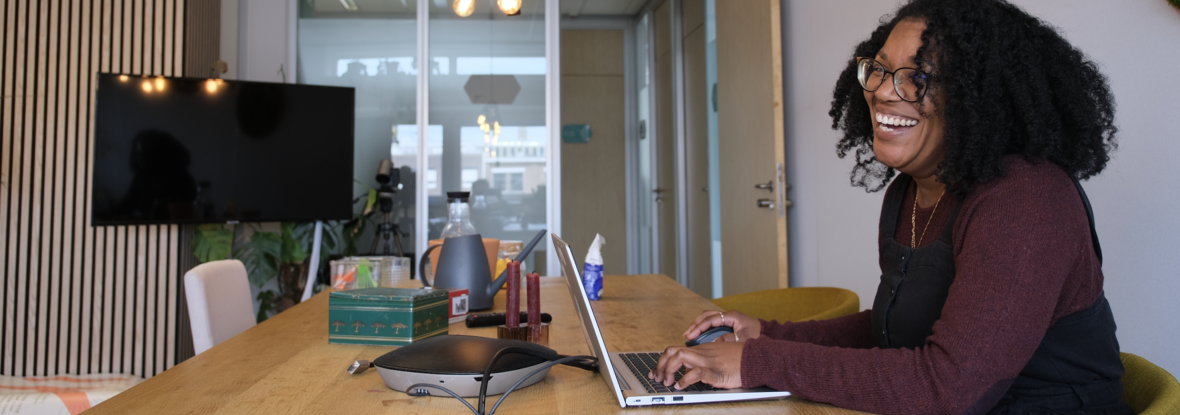 Collega Oglaya werkt op haar laptop aan tafel in kantoor Zwolle