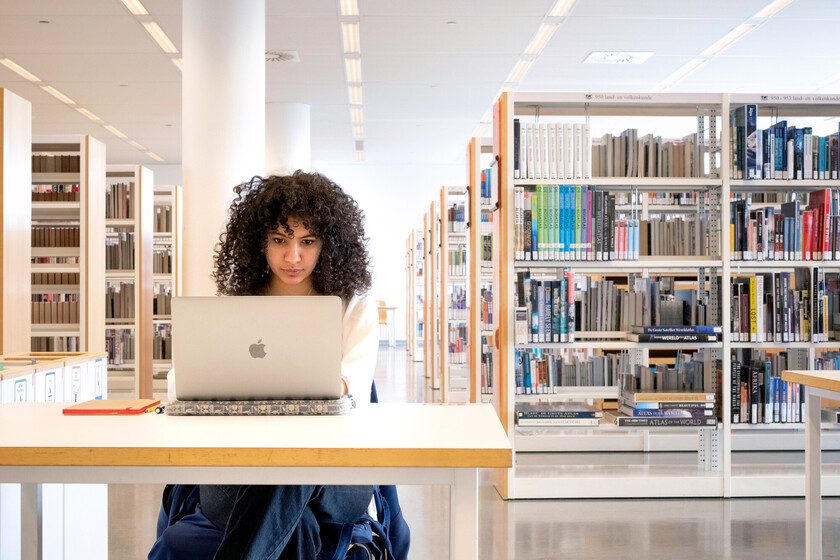 Vrouw studeert achter laptop in bibliotheek