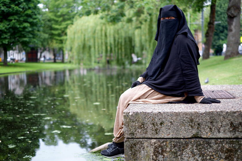Vrouw zit aan gracht in Rotterdam