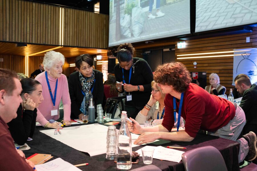Een groep mensen aan een tafel praat met elkaar