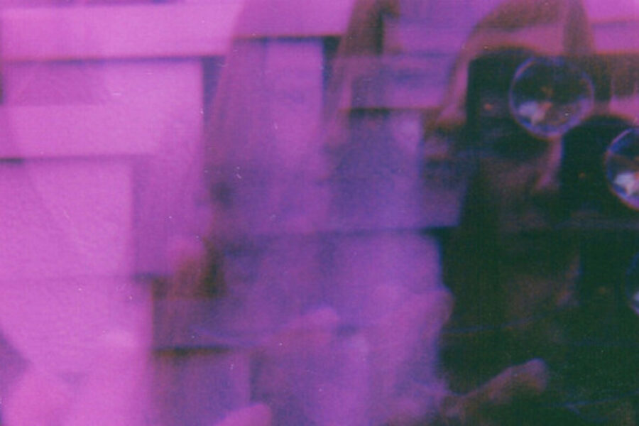Een vrouw maakt een foto met een analoge camera.