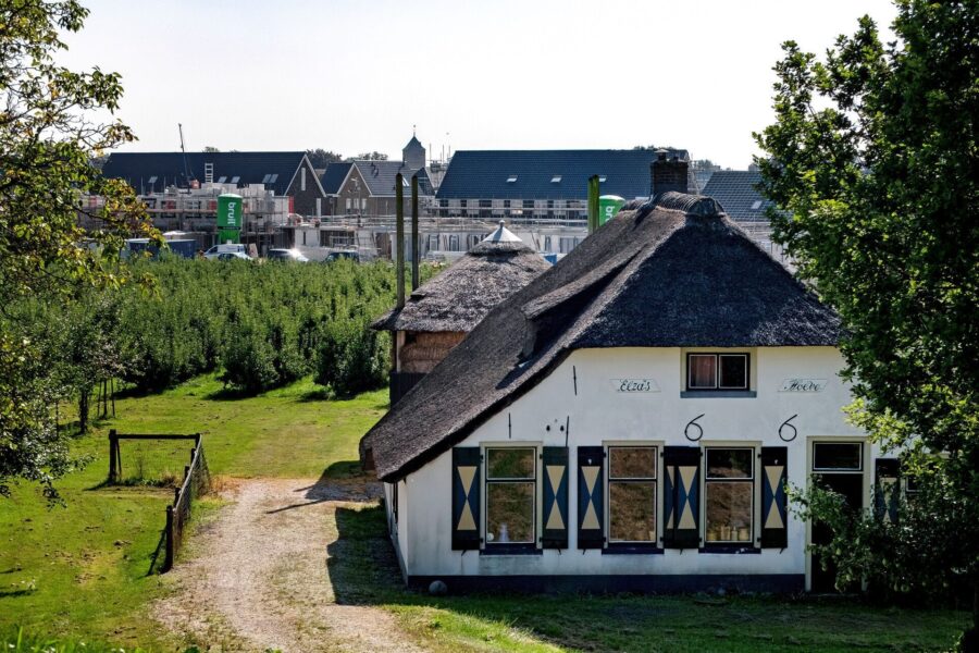oude boerderij met daarachter een nieuwbouwproject