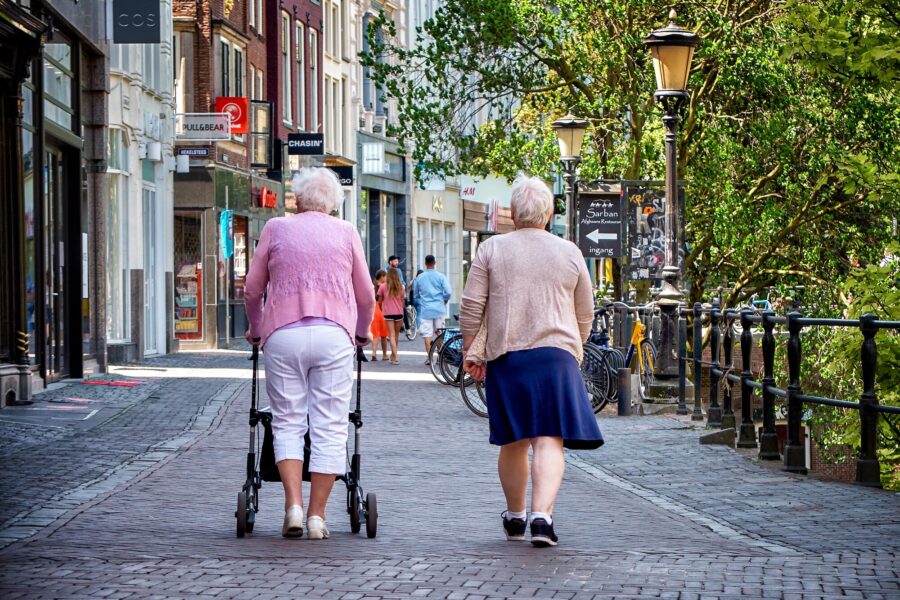 Twee oudere vrouwen lopen naast elkaar in het centrum