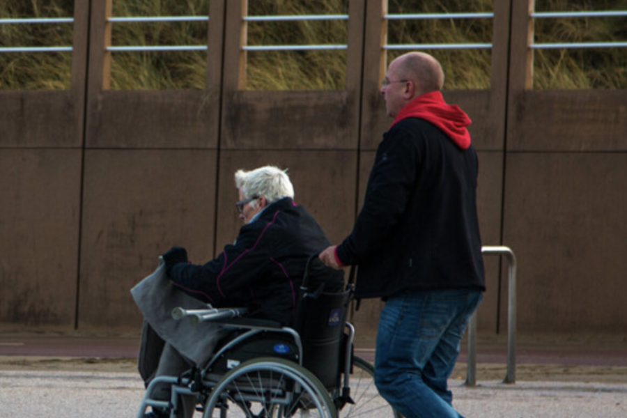 Man rijdt vrouw in rolstoel